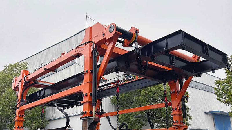 Sistema de izaje con cuatro puntos de suspensión y spreader telescópico inteligente del straddle carrier Aicrane para la manipulación segura y eficiente de contenedores de 20 y 40 pies en puertos secos.
